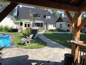 a backyard with a swimming pool and a house at B&B de Zandhoef in Eersel