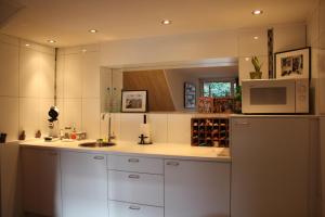 a kitchen with white cabinets and a microwave at De Buitenmuur in Turnhout