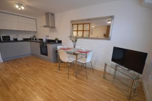 a kitchen with a table with chairs and a television at 4B Soho Studios 4th floor by Indigo Flats in London