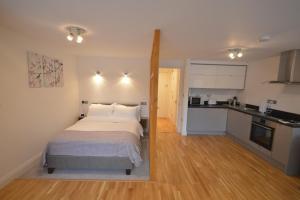 a bedroom with a large bed and a kitchen at 4B Soho Studios 4th floor by Indigo Flats in London