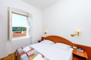 a bedroom with a bed and a window at Apartments Villa Eta in Cavtat