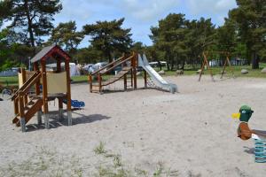 einen Spielplatz mit Rutsche im Sand in der Unterkunft Camp Am Wasser in Juliusruh