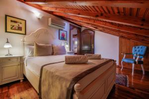 a bedroom with a large bed and a blue chair at La Paloma Hotel in Antalya