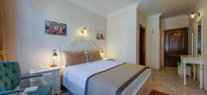 a bedroom with a bed and a chair in a room at La Paloma Hotel in Antalya