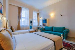 a hotel room with two beds and a couch at La Paloma Hotel in Antalya