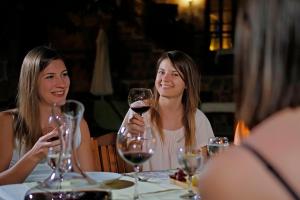 two women sitting at a table with a glass of wine at La Paloma Hotel in Antalya