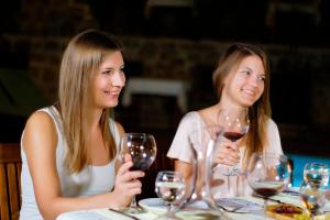 two women sitting at a table with wine glasses at La Paloma Hotel in Antalya