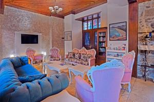a living room with a blue couch and pink chairs at La Paloma Hotel in Antalya