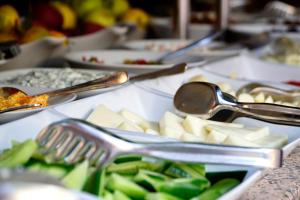 a table topped with plates of food with silver spoons at La Paloma Hotel in Antalya