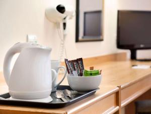a cup of coffee is sitting on a wooden table at Days Inn Kendal - Killington Lake in Kendal