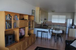 a kitchen and living room with a table and chairs at Bloubergviews in Bloubergstrand