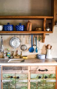 a kitchen counter with a sink and utensils on a shelf at Bolara 60: the Cottage in Grožnjan