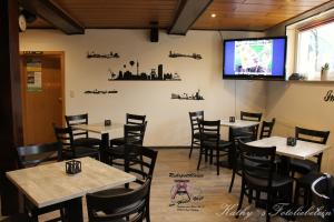 a dining room with tables and chairs and a tv at Hotel Vogt in Bad Driburg