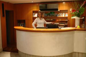 a woman standing at a counter in a room at Hotel Bahnhof Haus in Chiasso