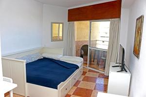 1 dormitorio con 1 cama y TV en Apartamentos Tamarindos, en Benalmádena