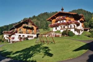 a large house on a hill with a grass yard at Feldlhof in Schladming