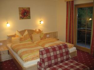 a hotel room with a bed and a chair at Feldlhof in Schladming +6 photos