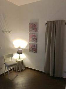 Zimmer mit einem Stuhl, einer Lampe und einem Vorhang in der Unterkunft La casina al Bargino in Bargino