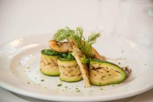 a white plate of food with cucumbers and dill at Villa Romana Hotel & Spa in Minori