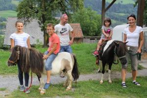 a family posing for a picture with a horse and a pony at Feldlhof in Schladming