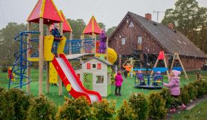 a group of children playing on a playground in the rain at Krapi Guesthouse in Treimani