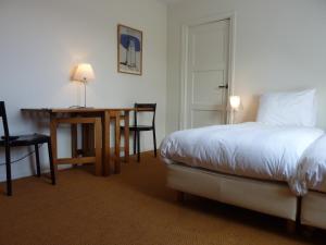 1 dormitorio con cama, escritorio y mesa en Alberti Bed & Bike en Maastricht