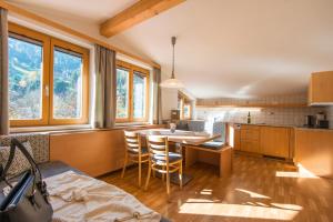 eine Küche mit einem Tisch und Stühlen im Zimmer in der Unterkunft KENDLGUT Appartements am BioBauernhof inklusive unbegrenztem Eintritt in die Alpentherme in Bad Hofgastein