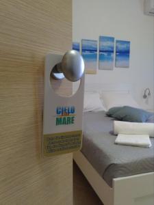 une porte avec un panneau à côté d'un lit dans l'établissement B&B Cielo & Mare, à Pozzallo
