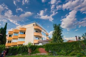 a yellow building with a fence in front of it at Apartments Panorama Ravda in Ravda