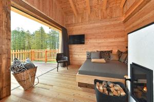 a log cabin with a bed and a fireplace at Chalet Leitner in Valles