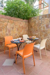 a patio with two tables and chairs with food on them at B&B Rose Villa in Peschici