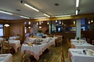 ein Restaurant mit Tischen und Stühlen mit weißen Tischdecken in der Unterkunft Hotel Valdotain in Villeneuve