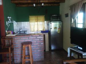 a kitchen with a brick counter and a refrigerator at Aire del Cerro in Capilla del Monte