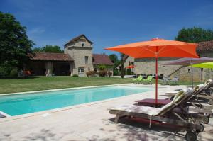 einen Pool mit Stühlen und Sonnenschirmen neben einem Haus in der Unterkunft Le Mas de Laché in Caylus