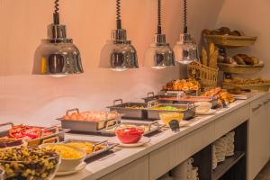 una línea de buffet con muchos tipos diferentes de comida en Hotel President, en Budapest