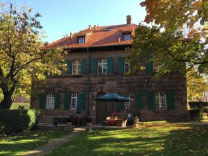 een oud huis met een tafel ervoor bij Forsthaus zu Lichtenhof in Neurenberg