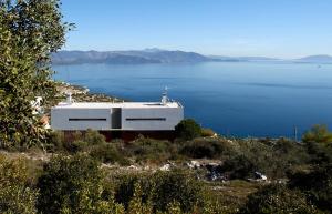 a white building on the side of a body of water at Seaview Villa Schinias in Schinias