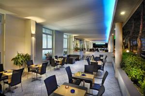 un restaurante con mesas y sillas de madera y una cafetería en Hotel Golf ***S en Bibione
