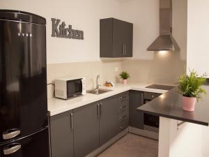 a kitchen with a refrigerator and a sink at Flats Friends Soho Suites in Valencia
