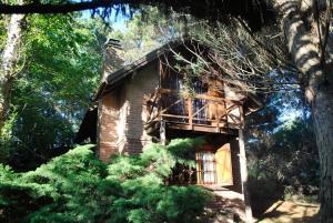 a log cabin in the middle of some trees at Cabañas Poetas del Bosque in Mar Azul