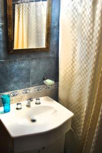 a bathroom with a sink and a mirror and a shower at Cabañas Poetas del Bosque in Mar Azul