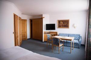 a hotel room with a bed and a table and a couch at Brauereigasthof ADLER in Herbertingen