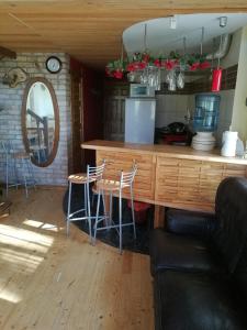 una cocina con barra y un bar con taburetes en Guest House Vējaines en Vecslavēkas