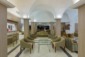 een lobby met stoelen en een tafel in een gebouw bij Hari Club Beach Resort in Aghīr