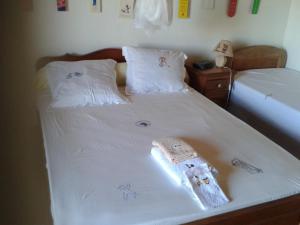 BG Tours في Ambohijanaka: سرير عليه شراشف بيضاء وفوط