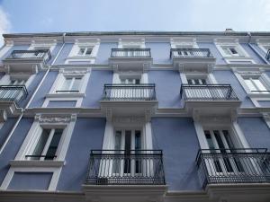 un edificio azul con balcones en un lateral en Flats Friends Soho Suites, en Valencia