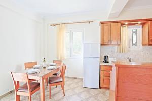 eine Küche mit einem Tisch und Stühlen sowie einem Kühlschrank in der Unterkunft Katerina House in Kalámi