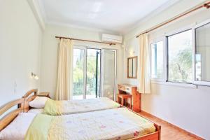 a bedroom with two beds and a window at Katerina House in Kalami