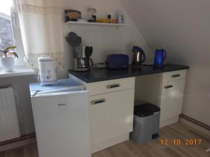eine kleine weiße Küche mit einer Theke und einem Waschbecken in der Unterkunft Ferienwohnung E.F. Schaper in Stadtoldendorf