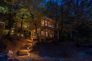 a house with lights on the stairs at night at TreeHouses Noszvaj in Noszvaj